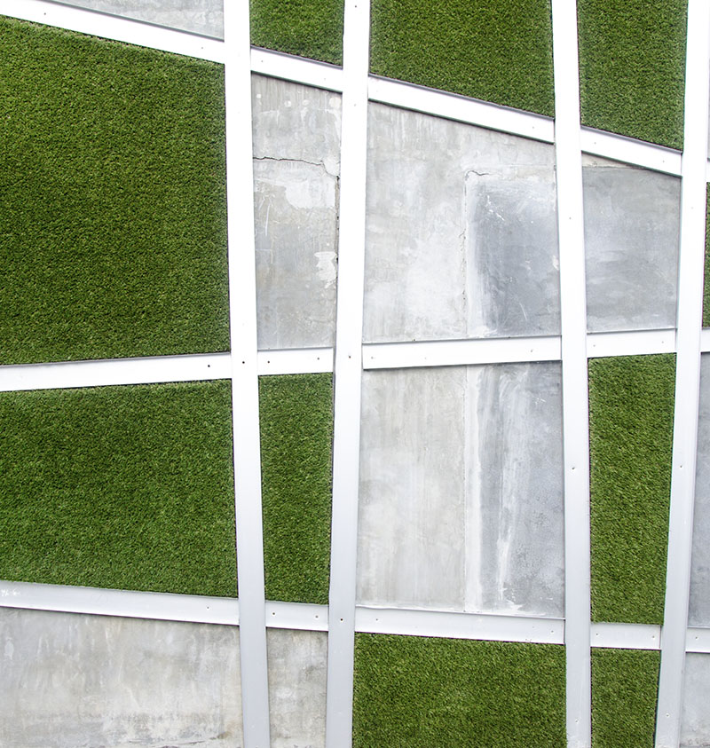 Cement wall with artificial grass background